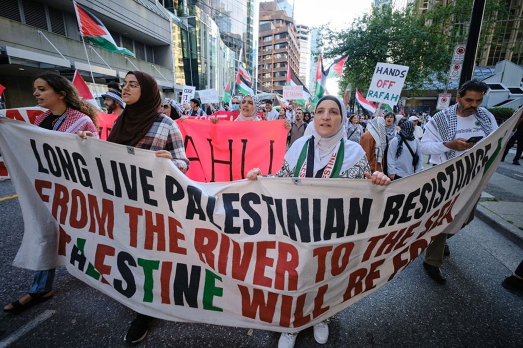 Protesters at the Samidoun and Masar Badil joint rally in Vancouver, Canada, hold a banner that reads, 'Long Live Palestinian Resistance, From the River to the Sea, Palestine Will be Free,' June 2024