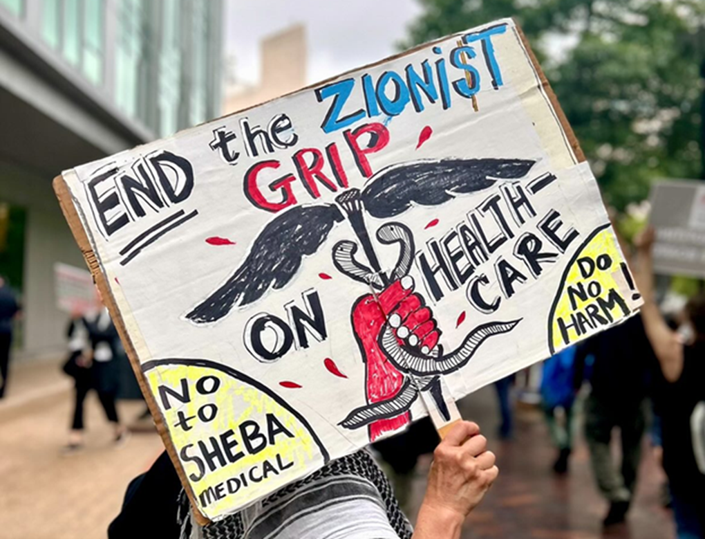 A sign reading “End the Zionist grip on healthcare,” seen at a Cambridge, MA, rally co-sponsored by HCW4P Boston