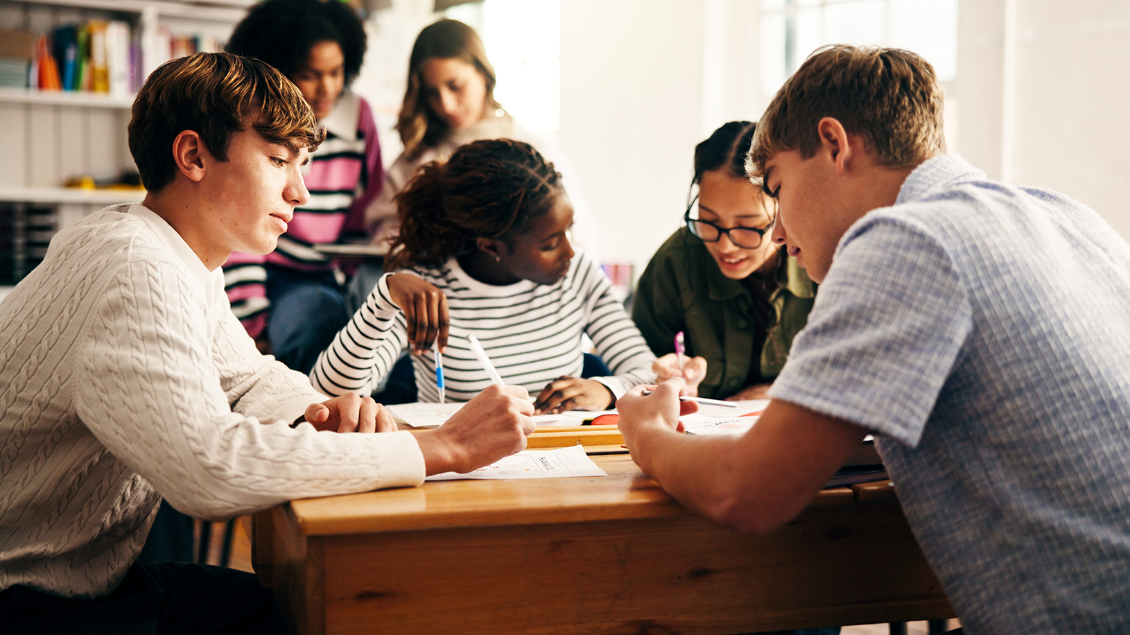 High school students working together at a table in a classroom