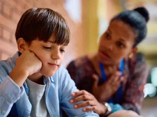 Boy being consoled by teacher