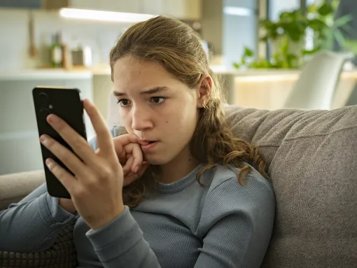 Teen girl looking at phone with concern