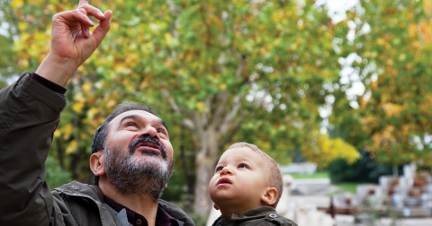 Jewish grandfather holding child and point to the sky