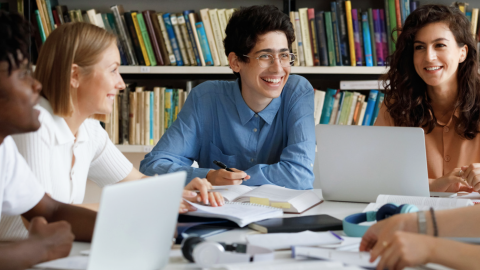 Group of diverse college students studying and laughing together