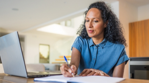 Woman sitting at desk looking at laptop