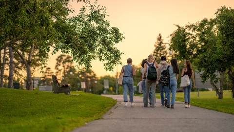 Teens walking and talking with backs turned to camera