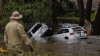 Vehicles sit submerged as a search and rescue worker looks through debris for any survivors or remains of people swept up in the flash flooding on July 6, 2025, in Hunt, Texas