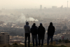 Photo: Men watch from a hillside as a plume of smoke rises after an explosion on March 2, 2026, in Tehran (Majid Saeedi/Getty Images).